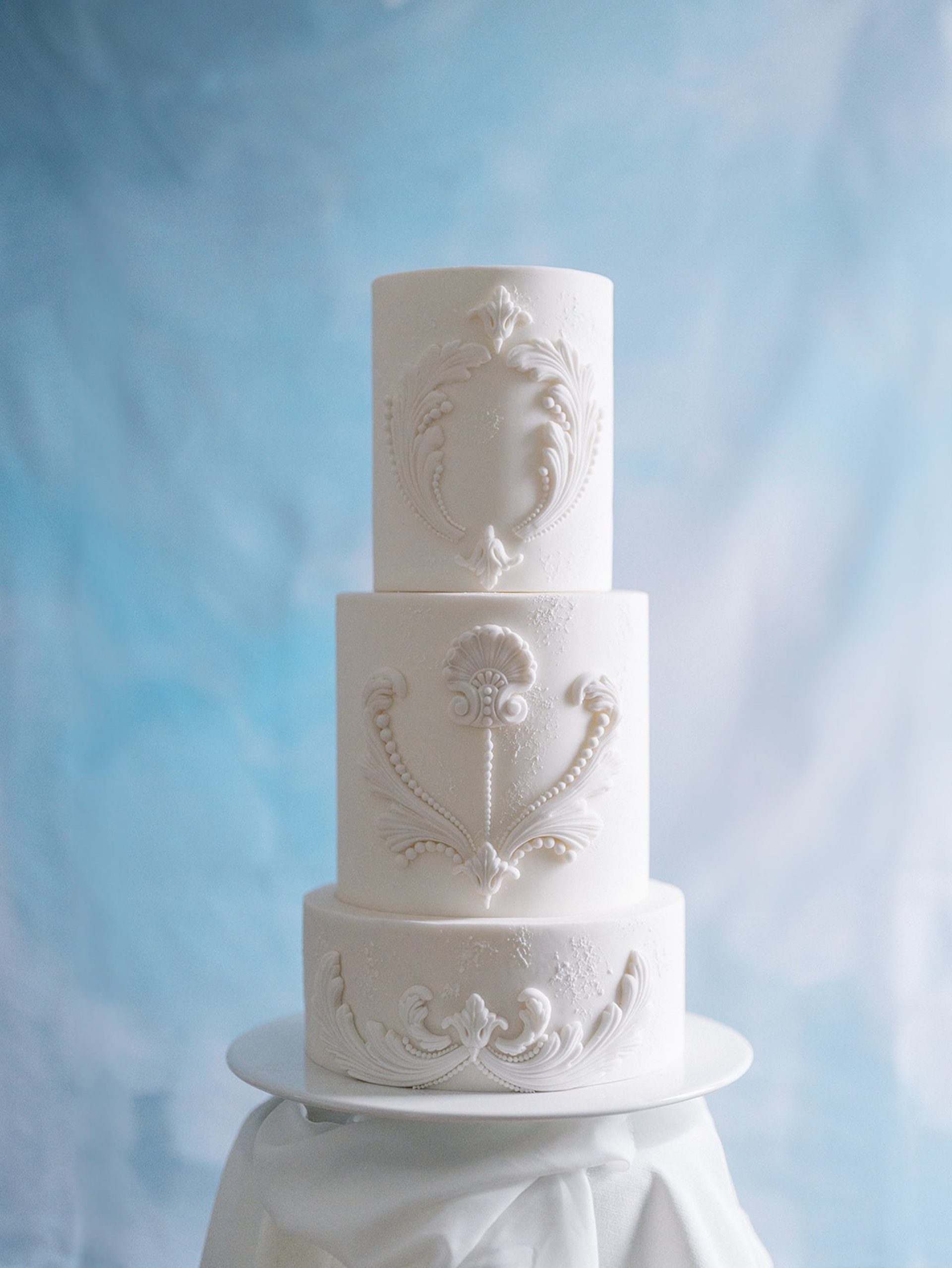 Close-up of hand-sculpted sugar paste detail on a luxury wedding cake